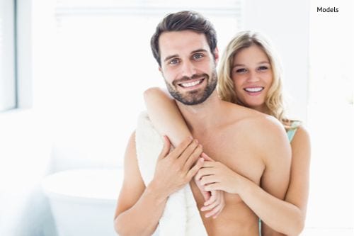 Portrait of happy young couple cuddling in the bathroom.