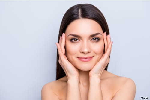 Woman touching sides of her eyebrows