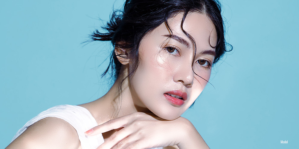 Asian female close up face on blue background