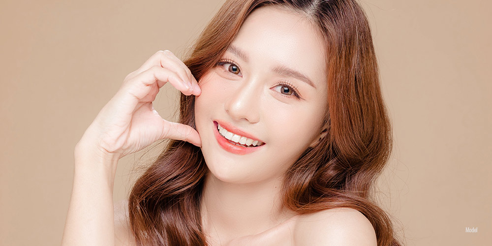 Beautiful red haired woman with her hand on her cheek