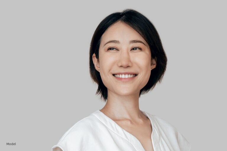 Asian woman smiling, short dark hair, white top