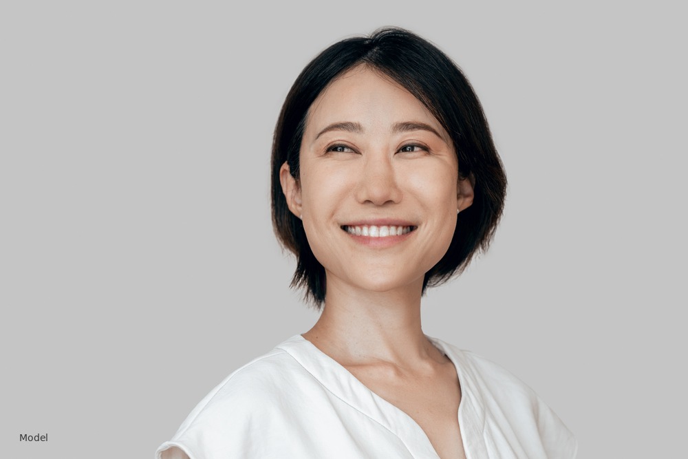 Asian woman smiling, short dark hair, white top